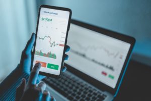 Trader using stock exchange app online for trading operations in mobile phone