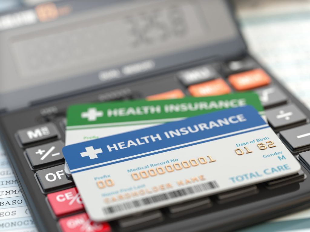 Medical insurance cards on the calculator. Health care costs con