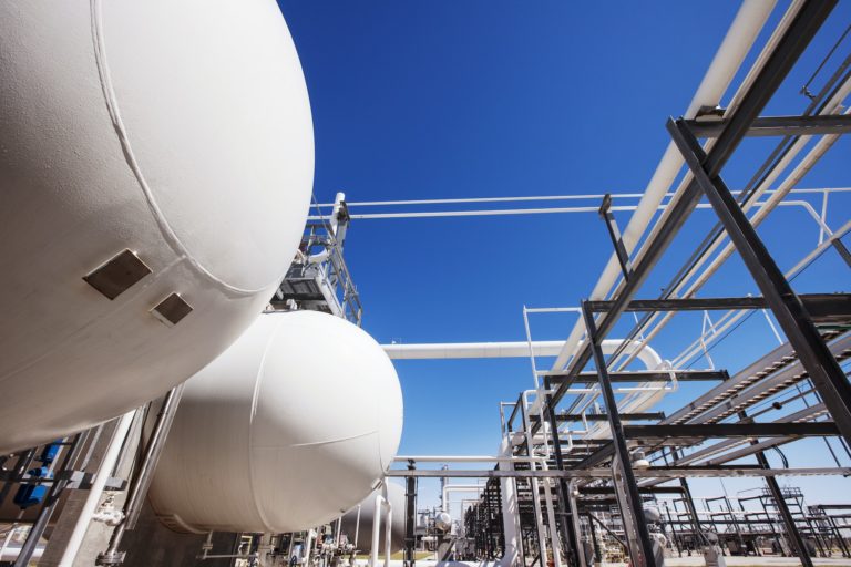 Natural Gas Tanks In Oil Refinery Against Clear Sky