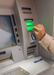 Woman inserting bank card into atm, Withdrawing money.