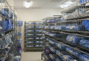 Storage room in a modern hospital, rows of sterile equipment packs in blue fabric.