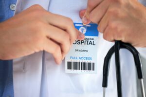 Hospital ID, doctor hands and clinic access pass of general health practitioner with stethoscope. I
