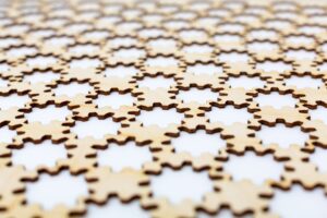 Abstract, background. Gear silhouette cut out in plywood on a white background selective focus